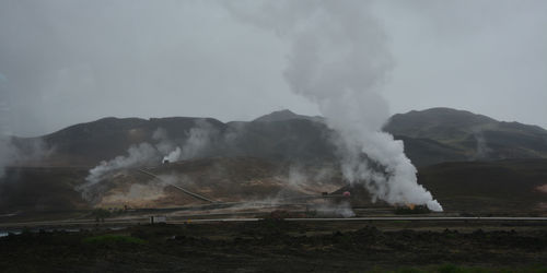 Smoke emitting from volcanic mountain against sky