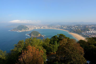 High angle view of city by sea against sky