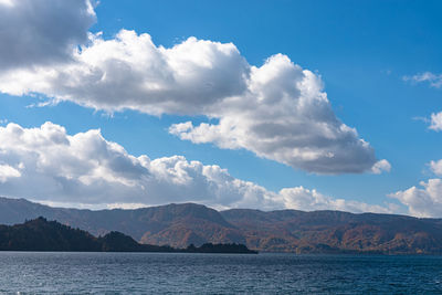 Scenic view of sea and mountains against sky