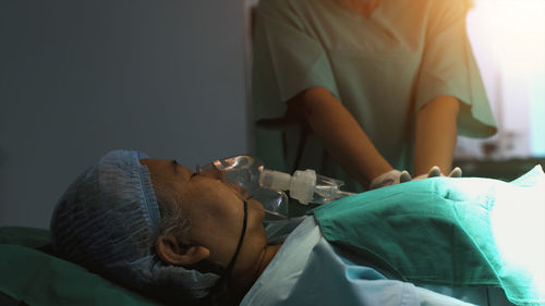 Side view of doctor giving massage to patient at home