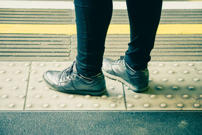 Low section of man standing on footpath