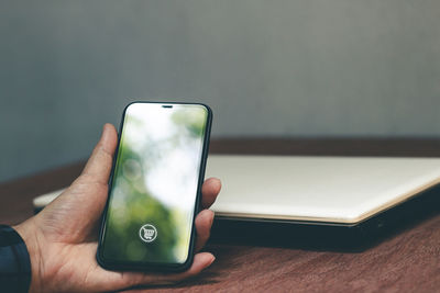 Midsection of person using mobile phone on table