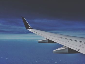 Cropped image of airplane flying over clouds