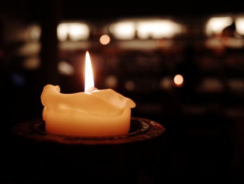 Close-up of lit candle on table