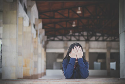 Sad woman with face covered by hands