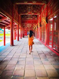 Full length rear view of woman walking in building