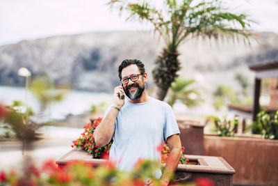 Man holding mobile phone outdoors