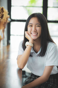 Portrait of smiling girl sitting at home