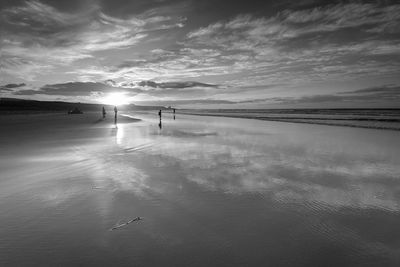 Silhouette of people walking on beach