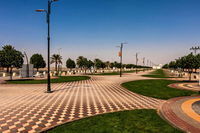 Footpath in park against clear sky