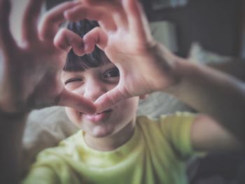 Portrait of boy making heart shape with hands
