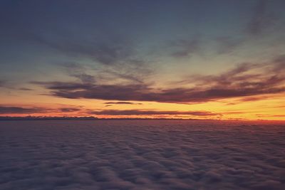 Scenic view of sea against dramatic sky during sunset