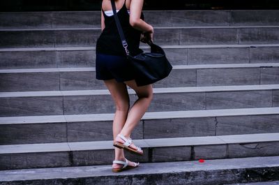 Low section of young woman moving on steps