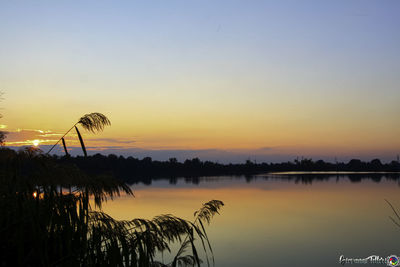 Scenic view of lake against sky during sunset