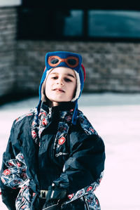 Portrait of smiling boy standing on snow covered field during winter