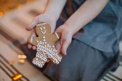 Midsection of woman holding gingerbread cookie