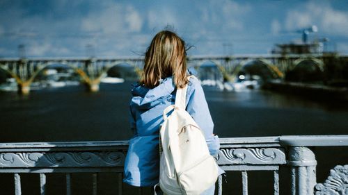 Rear view of woman on bridge over river
