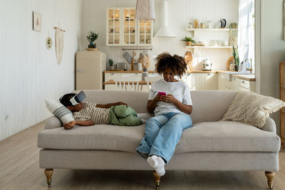 Young woman sitting on sofa at home