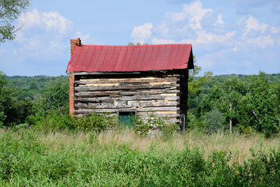 Abandoned house on field against sky