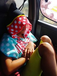 Boy wearing hood sleeping in car