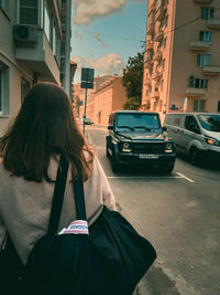 Rear view of woman sitting on street