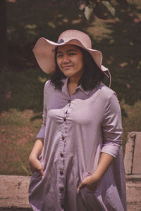 High angle portrait of a young girl wearing a hat and dress posing for the camera 