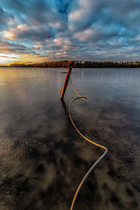 Scenic view of lake against sky at sunset