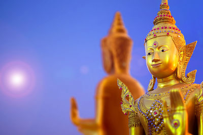 Statue against temple against clear blue sky