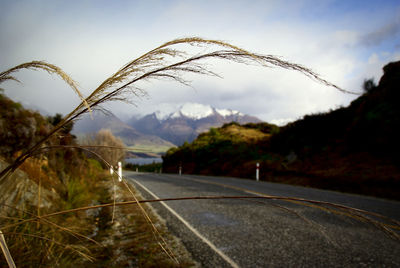 Road leading towards mountains against sky