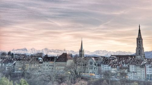 View of buildings in town against cloudy sky