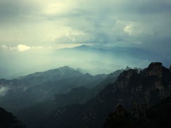 Scenic view of mountains against cloudy sky