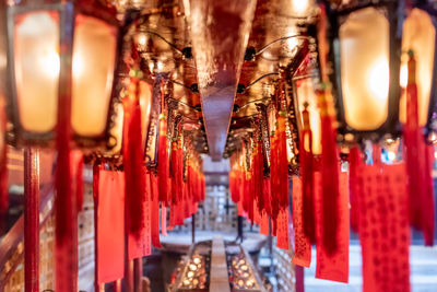 Illuminated lanterns hanging in temple outside building