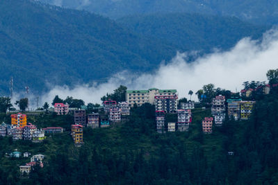 Panoramic view of buildings and trees against sky