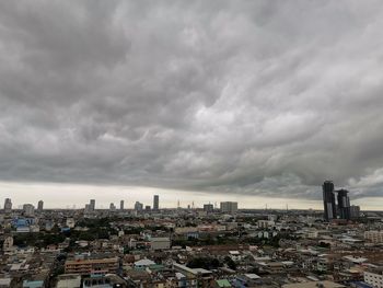 Panoramic view of buildings in city against cloudy sky