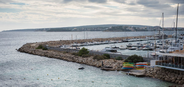 High angle view of boats moored at harbor against sky