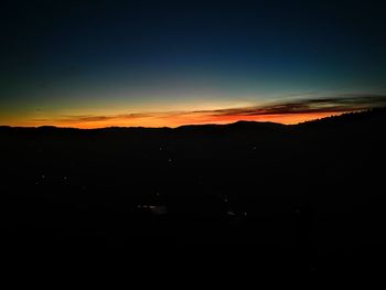 Silhouette landscape against sky at sunset