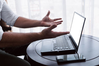 Midsection of man using laptop at home