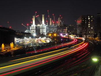 Light trails on road against sky at night