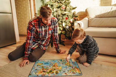 Father and son playing board game at home