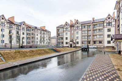 Canal amidst buildings against sky in city