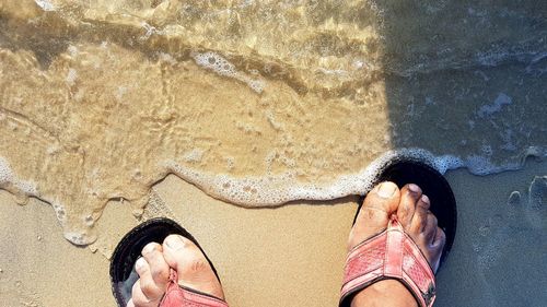 Low section of person at sea shore