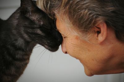 Close-up of woman face to face with cat at home