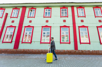 Woman walking on footpath against building