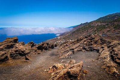 Scenic view of mountains against blue sky