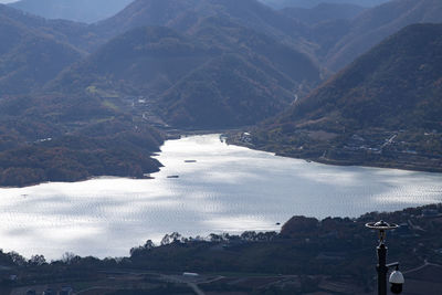 High angle view of lake and mountains against sky
