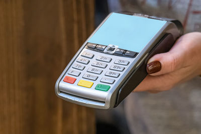 Cropped hand of woman holding credit card reader
