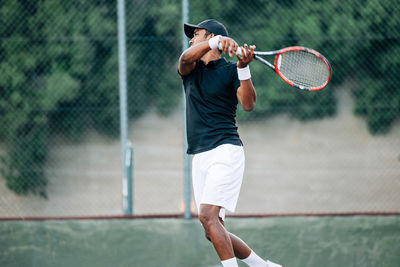 Midsection of man playing tennis