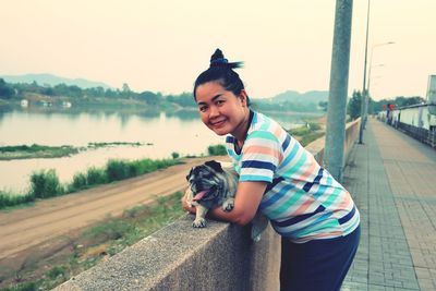 Portrait of man with dog standing in water