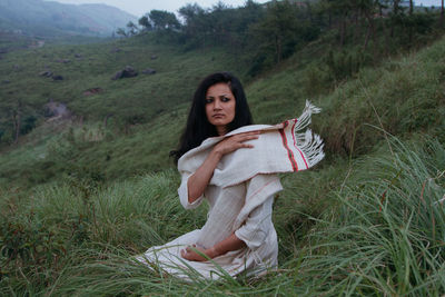 Portrait of young woman sitting on grass