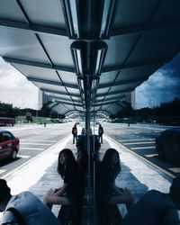 People on road by bridge against sky